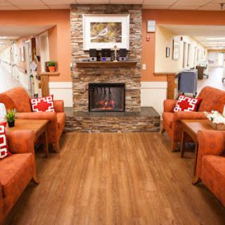 A cozy living room setup featuring orange chairs, a stone fireplace, and warm lighting.