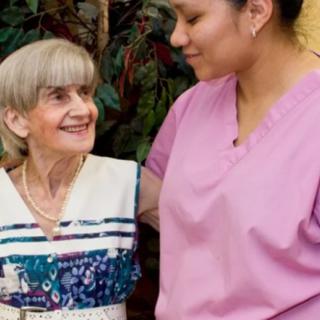 A caregiver providing support to an elderly woman.