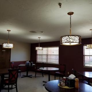 A cozy dining area featuring stylish lamps and comfortable seating.