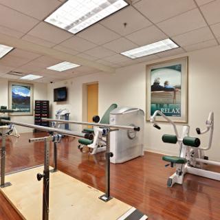 A well-equipped physical therapy room featuring various exercise machines and rehabilitation tools.