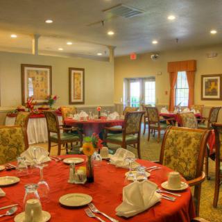 An elegant restaurant dining room with neatly set tables and comfortable chairs.