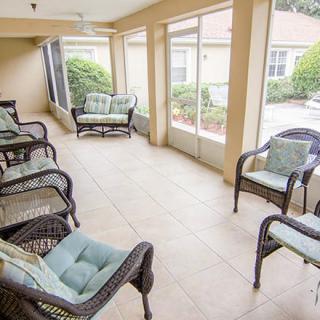A cozy, enclosed porch with wicker furniture and ample natural light.