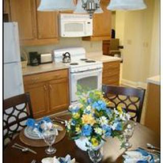 A cozy kitchen with a dining table adorned with a colorful floral arrangement.