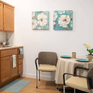 Cozy kitchen and dining area with floral artwork on the wall.
