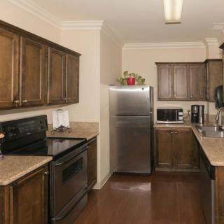 A modern kitchen with wood cabinets and stainless steel appliances.