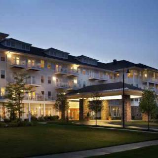 A well-lit apartment building at dusk, showcasing its architectural design.
