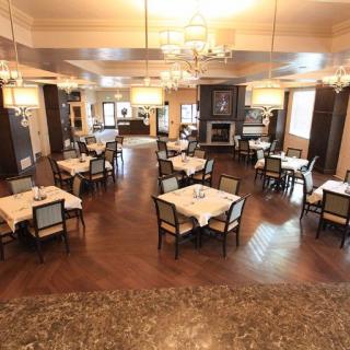 An elegant restaurant dining room with neatly arranged tables and chandeliers.