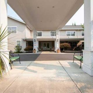 The entrance of a building with a covered walkway and benches on either side.