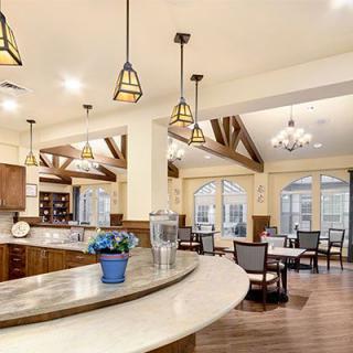 A spacious and modern kitchen and dining area featuring elegant lighting and wood flooring.