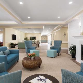 A spacious and elegantly designed living room with blue seating and a fireplace.