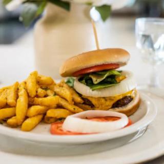 A delicious burger served with crispy fries on a white plate.