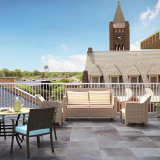 A scenic rooftop with comfortable seating and a view of urban architecture.