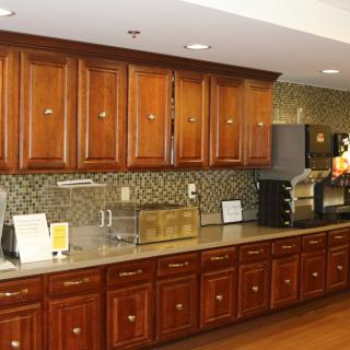 A modern kitchen with wooden cabinetry and various appliances.
