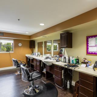 An interior view of a beauty salon with chairs, mirrors, and hairdressing equipment.