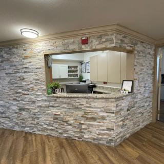 A modern reception area with a stone wall and wood flooring.