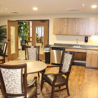Modern kitchen and dining area with wooden flooring and elegant furniture.