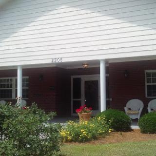 A welcoming front view of a house with a porch and garden.