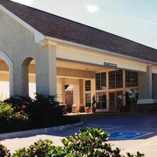 The exterior of a building with an entrance area and surrounding landscaping.