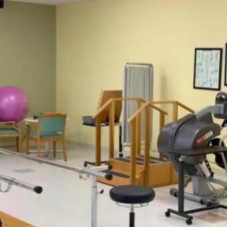 A physical therapy room equipped with exercise machines and a fitness ball.