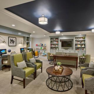 A cozy living room with modern furnishings, bookshelves, and comfortable seating.