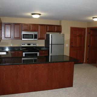 Modern kitchen with stainless steel appliances and dark countertops.