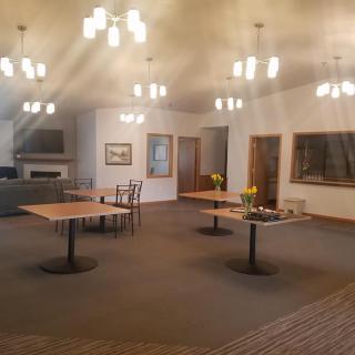 A spacious and modern dining room with tables, chairs, and elegant lighting.