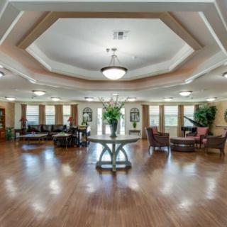 A spacious and elegantly decorated lobby with wood flooring and comfortable seating.