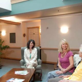 A group of people sitting and conversing in a comfortable indoor setting.