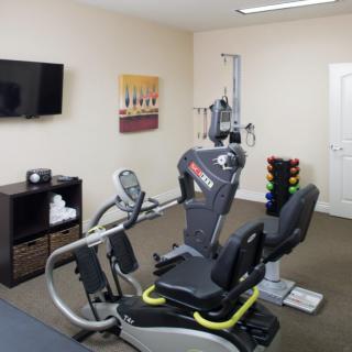 A fitness room featuring a cardio machine and weights.