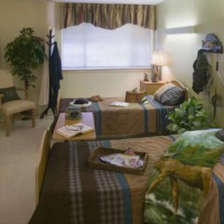 A cozy bedroom with twin beds, decorated with plants and soft lighting.