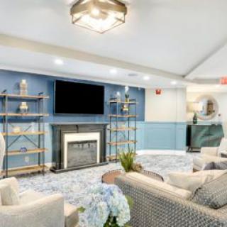 A modern living room with a cozy fireplace, blue accents, and stylish shelving.