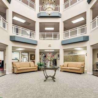 A spacious and modern lobby interior with sofas and decorative plants.
