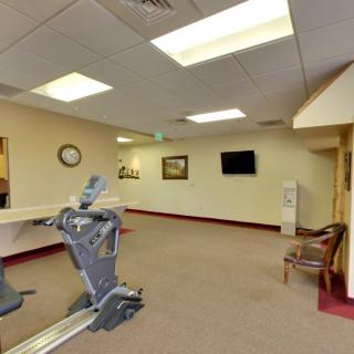 An empty fitness room with a treadmill and ceiling lights.