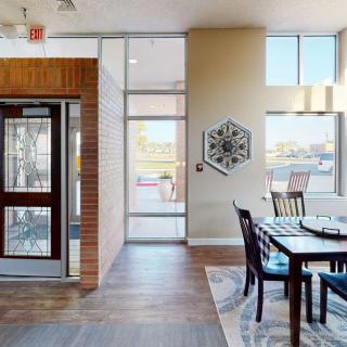 A modern dining area with wooden flooring and a nearby elevator, showcasing contemporary interior design.