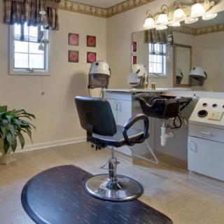 A well-lit hair salon interior with a styling chair, large mirror, and sink.