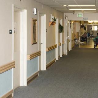 A long, empty hallway with multiple doors on either side and a carpeted floor.
