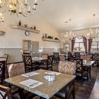 Elegant dining room with chandeliers and neatly arranged tables.