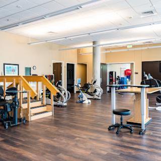 A spacious and modern gym area equipped with various exercise machines.