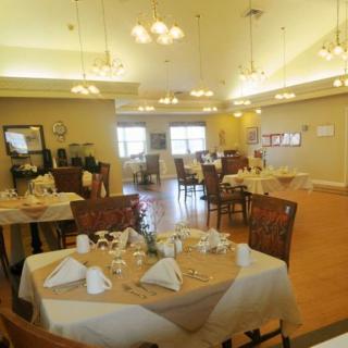 A well-lit dining room with neatly arranged tables and chairs.