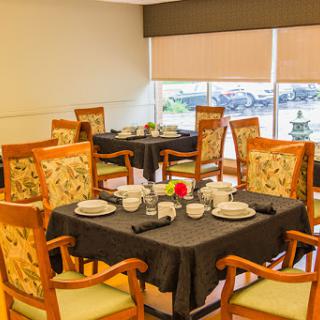 A cozy dining area featuring elegantly set tables and comfortable chairs.