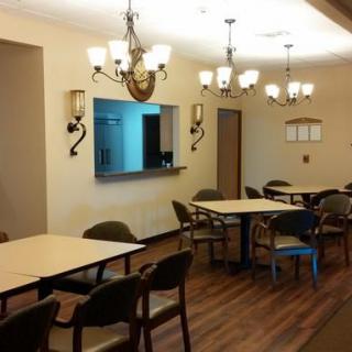 A spacious dining area with multiple tables and chandeliers.