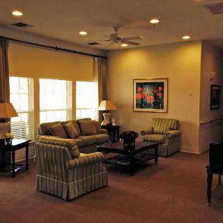 A cozy living room with comfortable seating, a coffee table, and warm lighting.