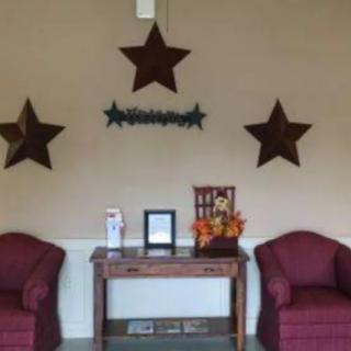 A cozy waiting area with red chairs and star decorations on the wall.