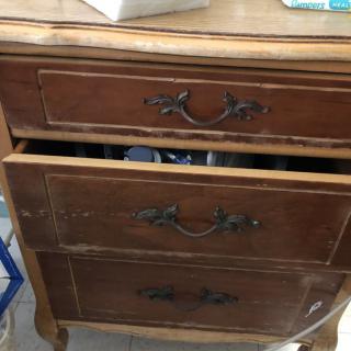 A vintage wooden dresser with partially open drawers.