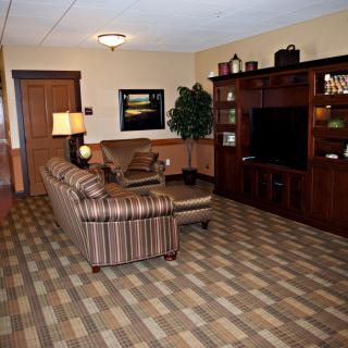 A cozy living room with a sofa, television, and coffee table on a patterned carpet.