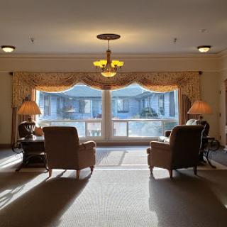 A cozy seating area bathed in daylight, featuring two armchairs and a window view.