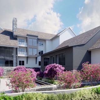 A modern residential house with well-landscaped gardens featuring vibrant flowers.