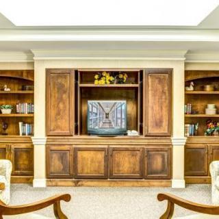 A traditional living room featuring wooden bookshelves and a TV cabinet.
