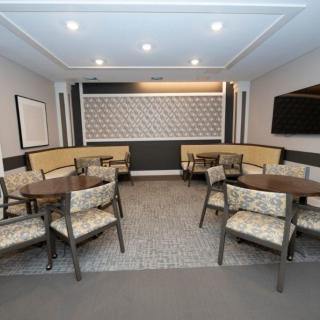 A modern dining area with several tables and chairs, featuring stylish decor and a mounted television.