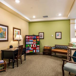A cozy waiting room with colorful flags, artwork, and various seating options.